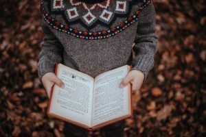 Kid Reading in the fall foliage