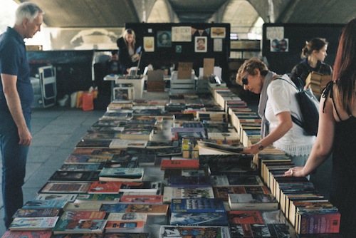 Photo of woman looking at books on a table