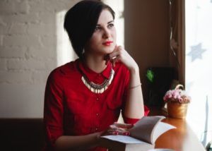 woman thinking while reading a book