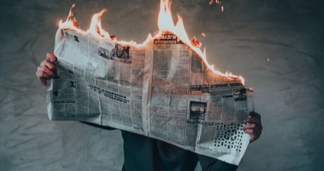 burning newspaper bad news feature