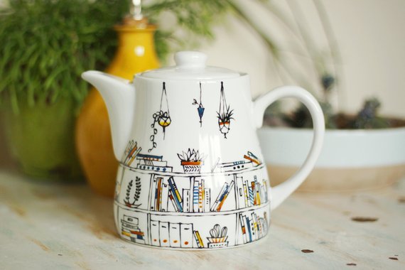 hand-painted porcelain teapot with bookshelves and hanging plants