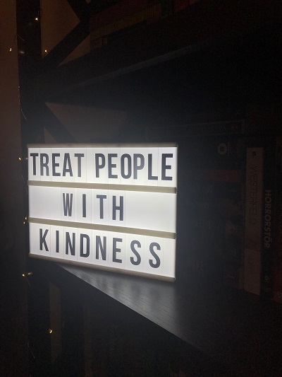 'treat people with kindness' quote on a light box