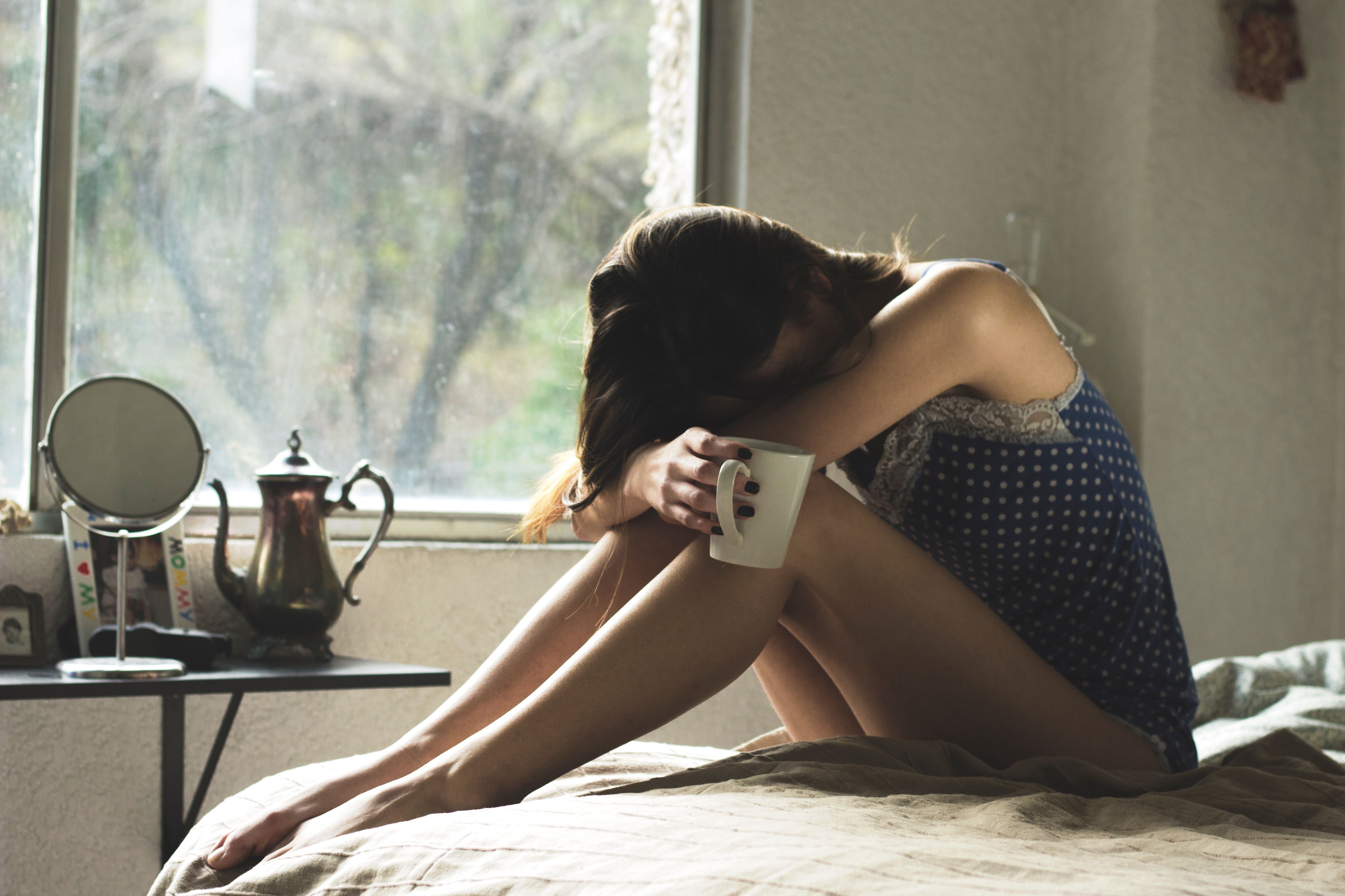 I can't stop crying at the end of books: Sad woman sitting on bed