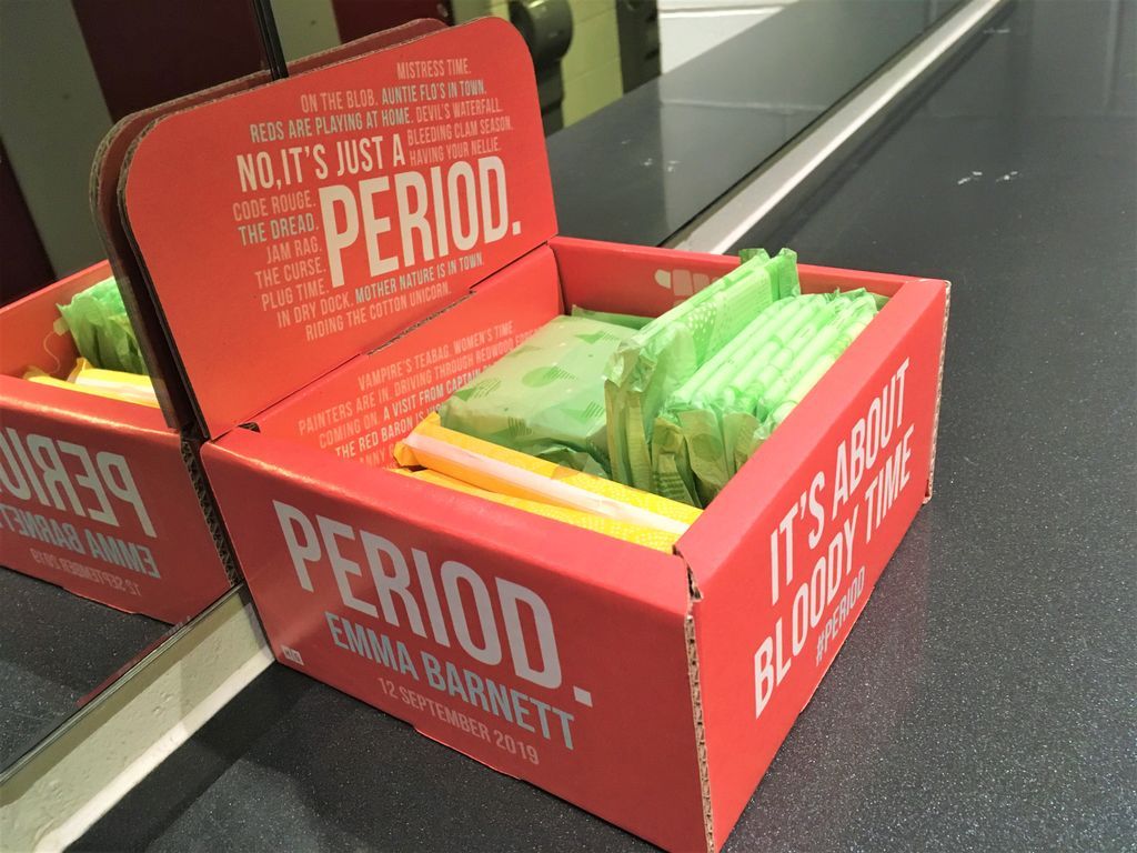 A pink box with the text "Period" and "It's about bloody time", containing sanitary products