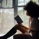 black woman reading in window home page feature