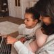 child and mother looking at a laptop feature