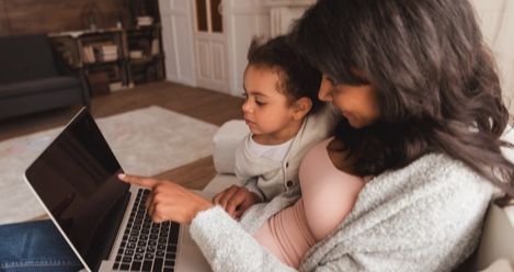 child and mother looking at a laptop feature