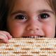 child eating matzah for Passover Judaism feature