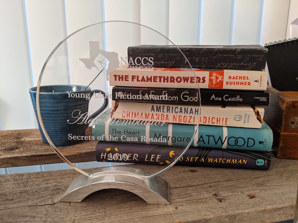 Books on an author's desk. Used with permission from the owner of the photo, Alex Temblador.