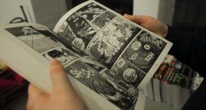 a photo of someone holding open a manga volume