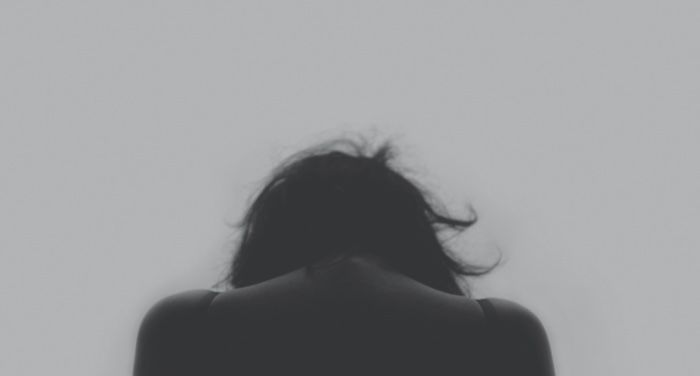 woman dealing with grief sadness or depression with back turned in black and white