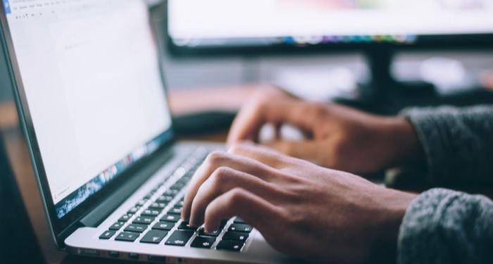 image of a person writing on a laptop computer