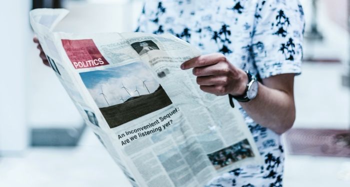 a photo of someone reading the paper