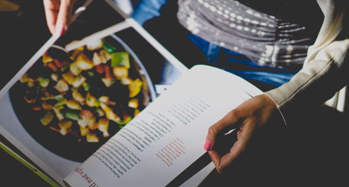 someone holding an open cookbook