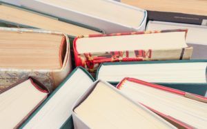 (Source: https://www.pexels.com/photo/books-indoors-pages-paper-45717/) Assorted books (in various book formats) standing spine to spine.