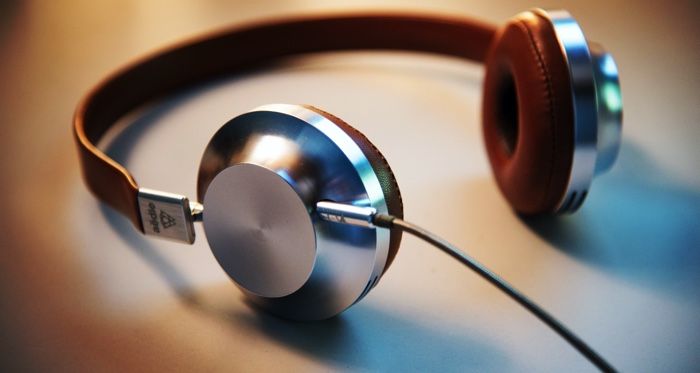 a photo of a pair of silver and rust-colored headphones