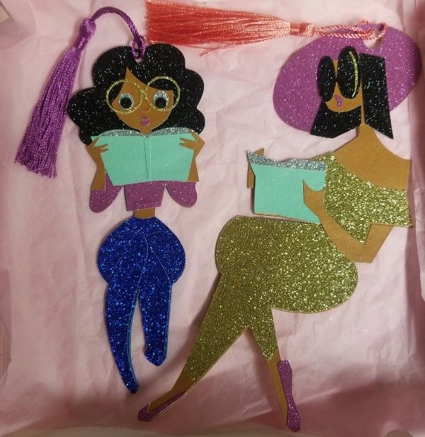 Two bookmarks of black girls reading cut out of glitter paper