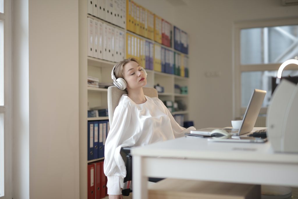 Female-presenting person sleeping with headphones on