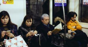 elderly woman reading on the subway