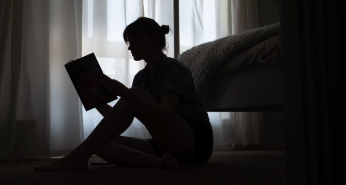 woman reading a book in the dark