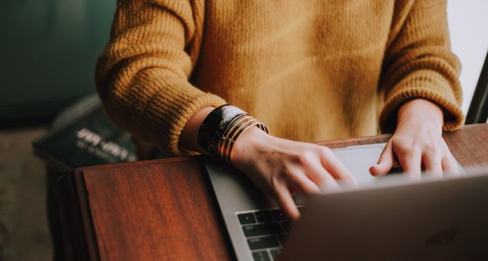 a photo of a woman writing on laptop