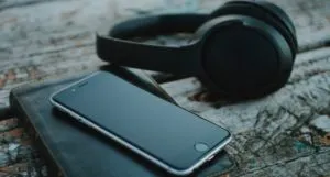image of a pair of black headphones and a cell phone resting on a journal
