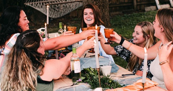 friends gathered for dinner around an outdoor table for cookbooks for supper clubs