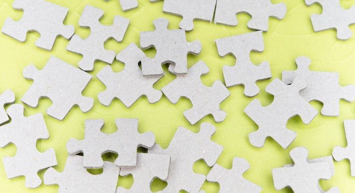 Image of white puzzle pieces on a yellow background