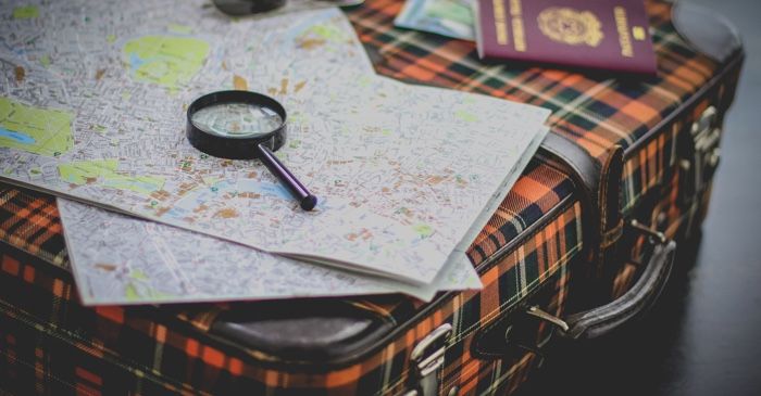 magnifying glass on suitcase and map