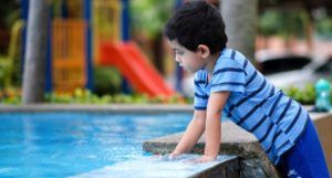 Malaysian South Asian child looking into water fountain