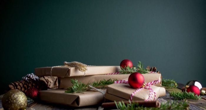 image of a stack of wrapped presents with red baubles on top https://unsplash.com/photos/LUPXhXj2ip0