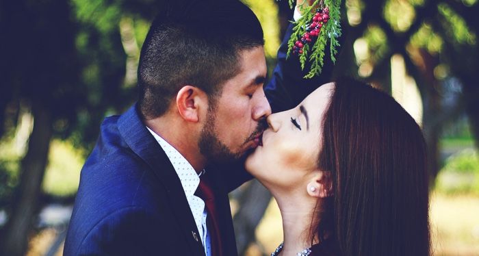 couple kissing under mistletoe for christmas holiday romance
