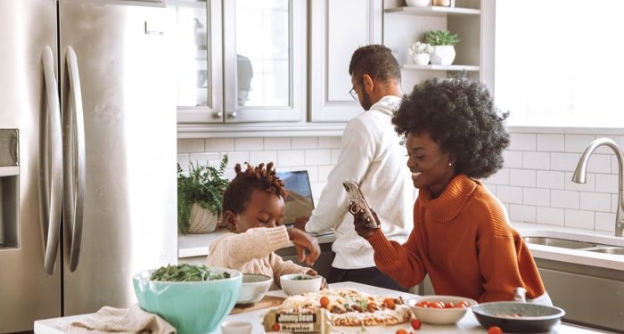 family cooking and eating in a kitchen