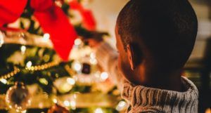 image of a child placing ornament on a christmas tree