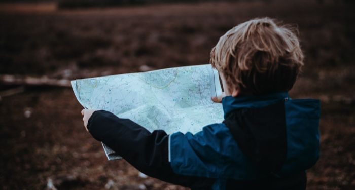 a young child looking at a map outdoors