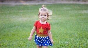 A young child wearing a wonder woman costume