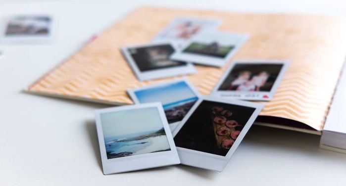 image of scattered Polaroid photos on an open scrapbook