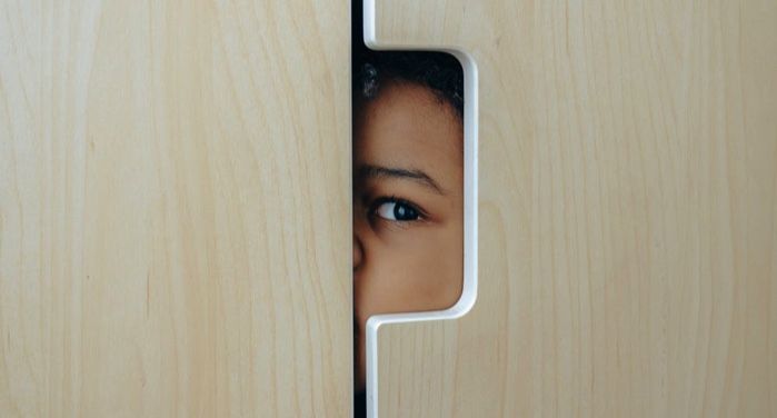 image of a child hiding in a wardrobe https://www.pexels.com/photo/anonymous-black-little-kid-hiding-in-wardrobe-4545989/