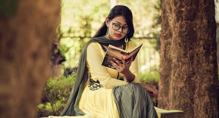 woman reading a book on a park bench between two trees https://www.pexels.com/photo/woman-reading-book-1580272/