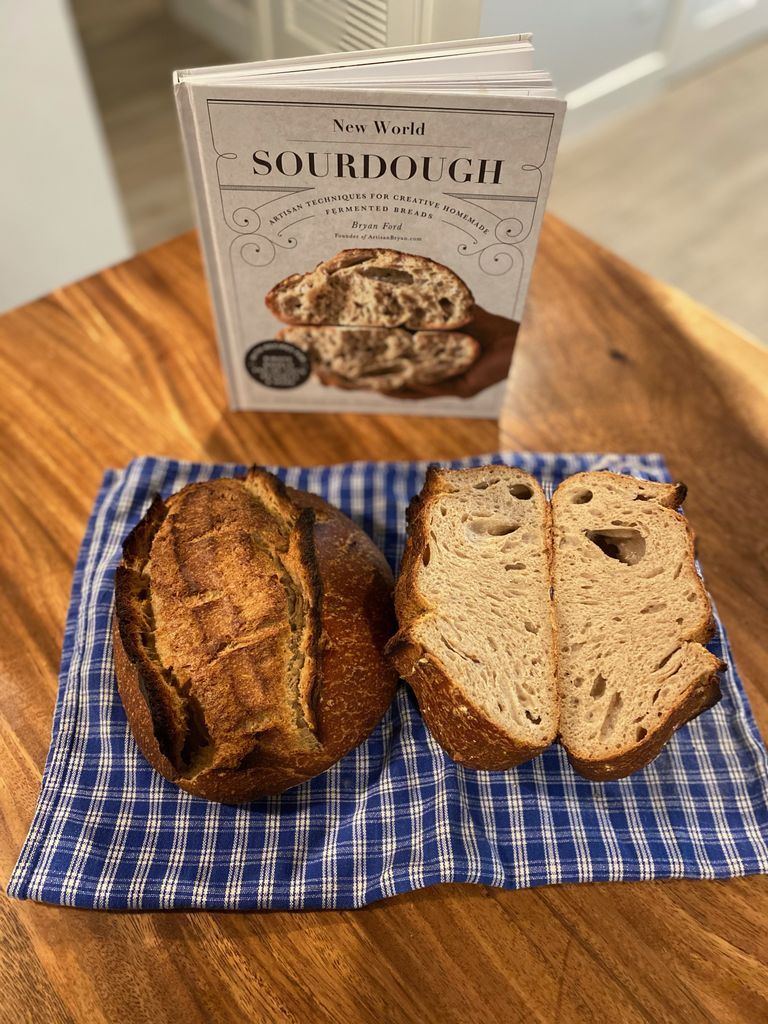 New World Sourdough cookbook with baked loaves