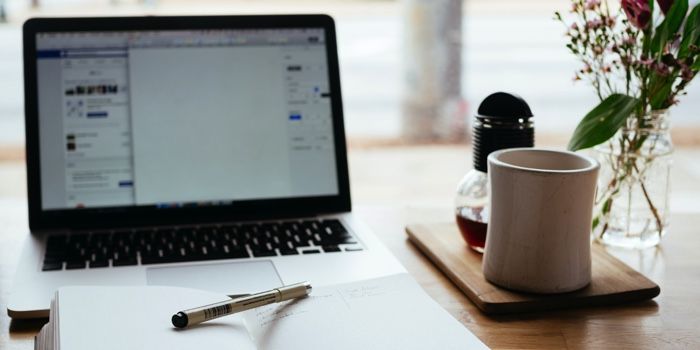 a photo of a laptop, notebook and coffee on a table at a cafe