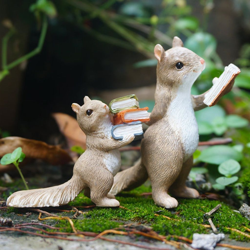 Two squirrel figurines carrying books