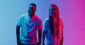 two people laughing, lit in neon light