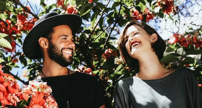 a man and woman surrounded by pink and orange flowering plants https://unsplash.com/photos/ODMNSWjel_I