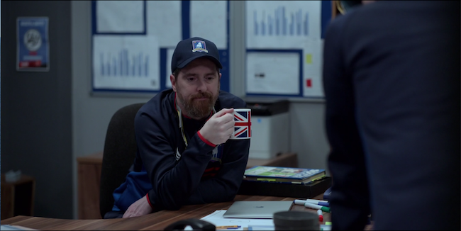 Beard sites at his desk holding a union jack mug