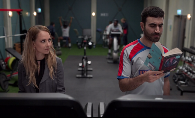 Roy reading A Wrinkle in Time on the treadmill while Keeley glances over at him