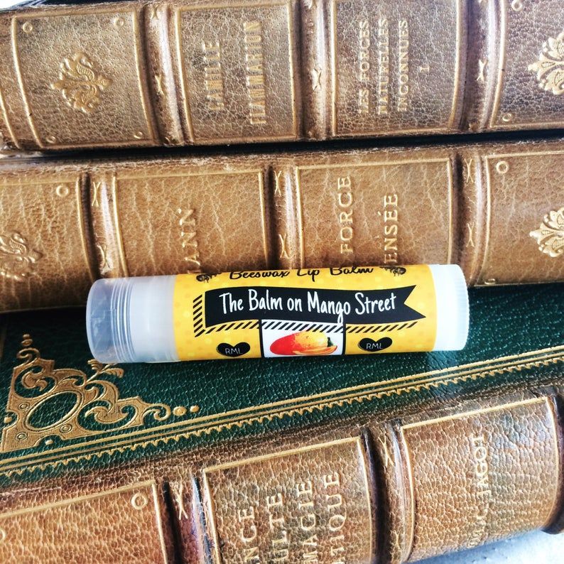 Balm on Mango Street lip balm in front of old books.