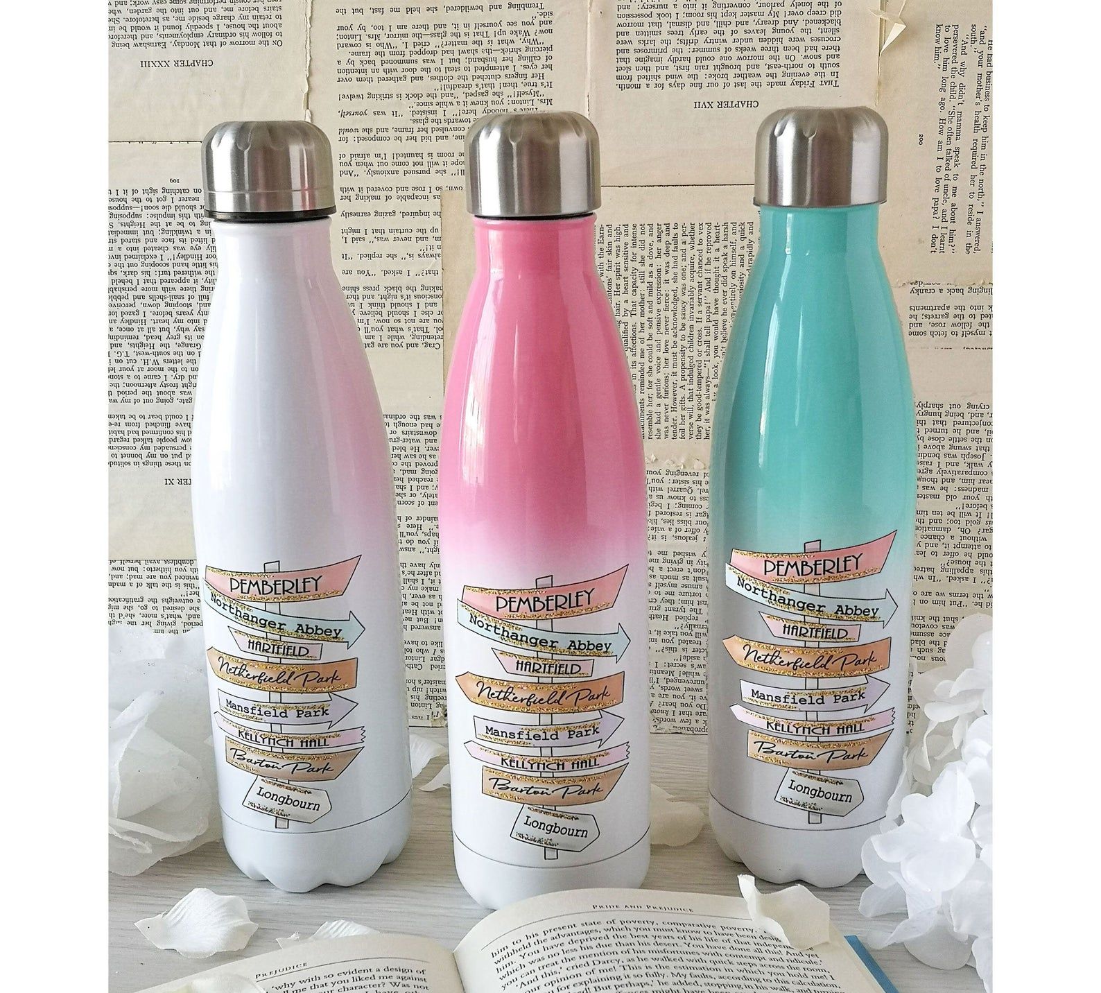 White, pink, and green gradient water bottles with road signs containing places from Jane Austen novels on them