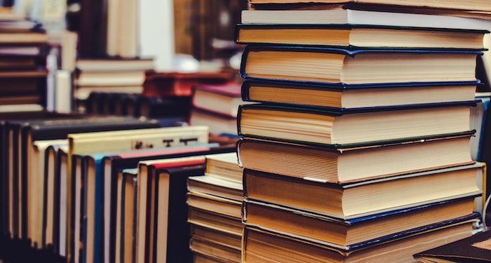 several stacks of books piled vertically and arranged horizontally