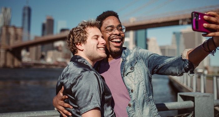 two men smiling and taking a selfie